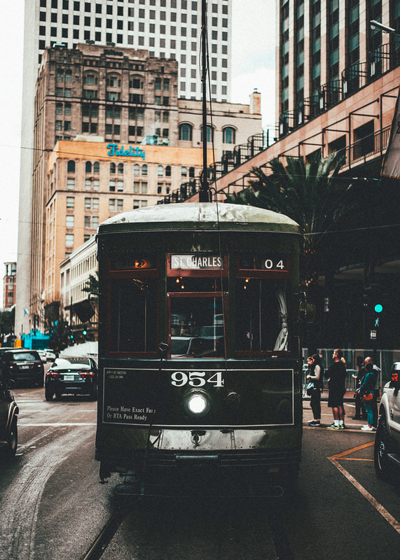 A photograph of a street car driving down New Orleans Canal St.