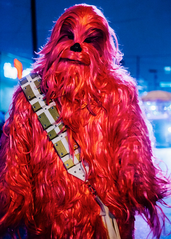 A photograph of a man dressed as a pink Chewbacca from Star Wars, taken during Mardi Gras Intergalactic Krewe of Chewbacchus Parade.